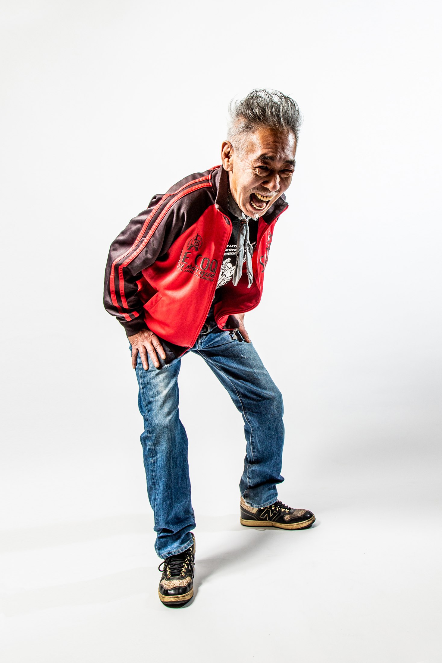 赤いジャケットとジーンズで笑う男性