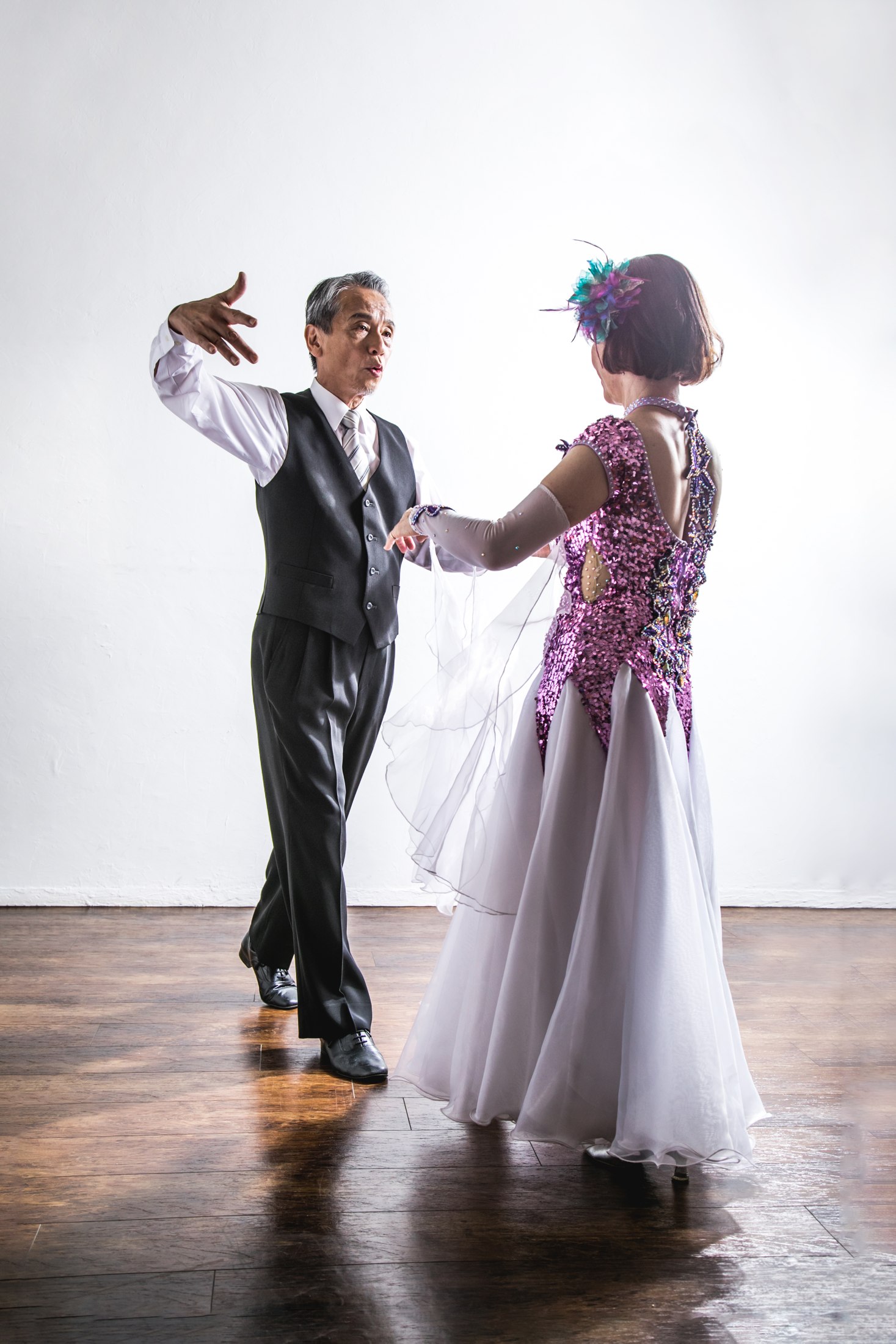 明るい空間で手を取り合って踊る二人