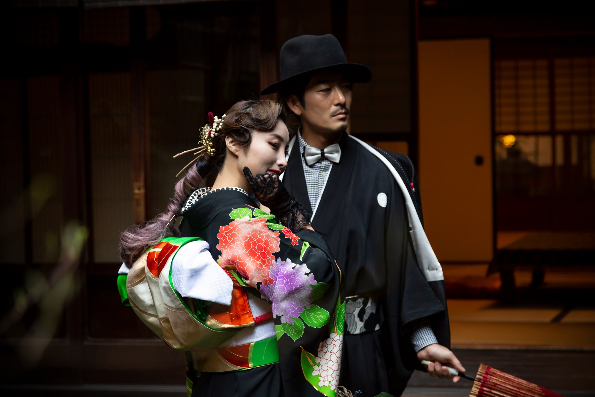 花柄の着物を着た女性と、帽子と紋付を合わせた男性のポートレート