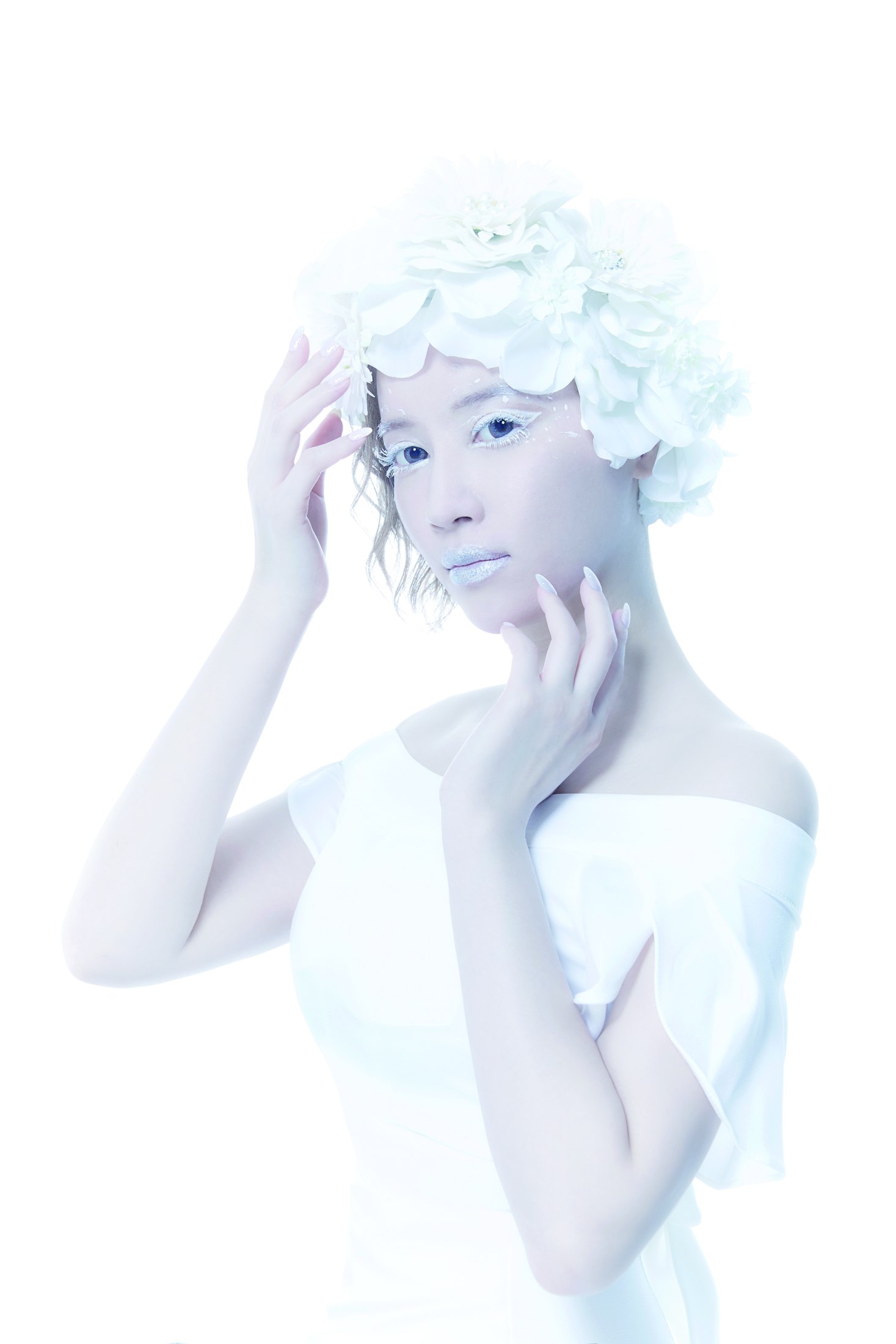 白い花飾りと白いメイクをまとった女性